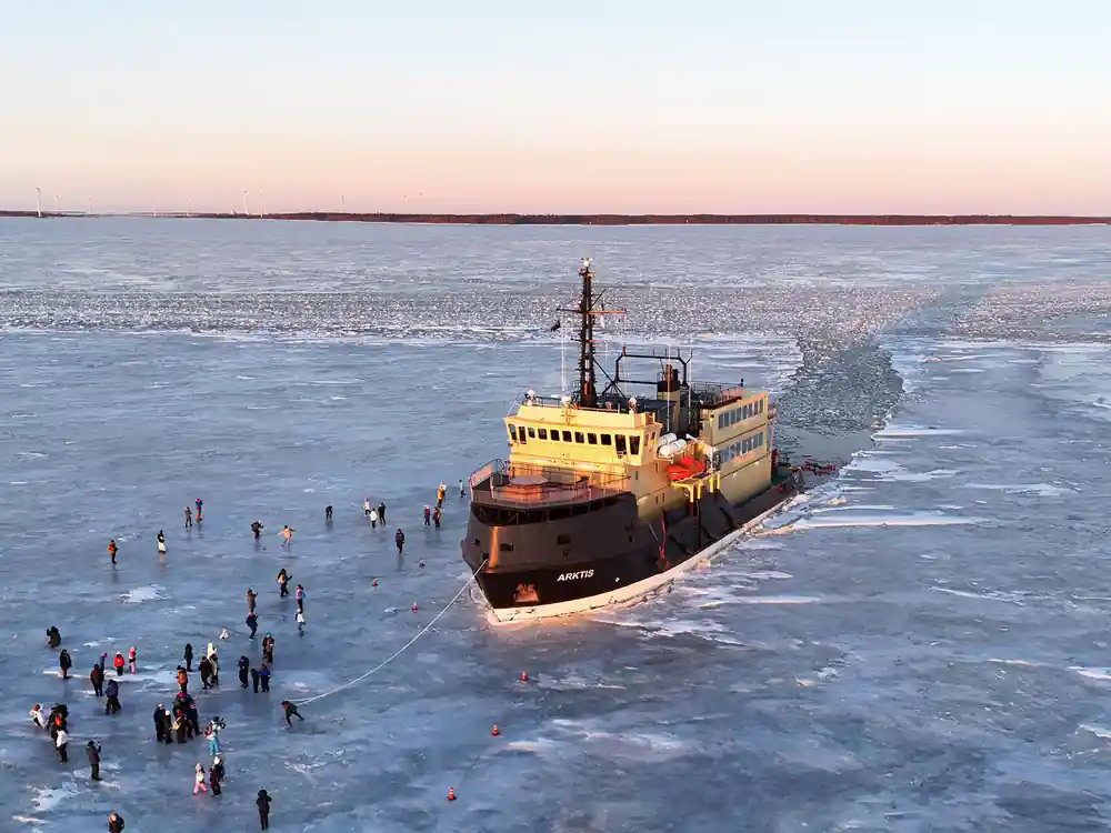 Aerial view of the ship in the ice with people spread across the field