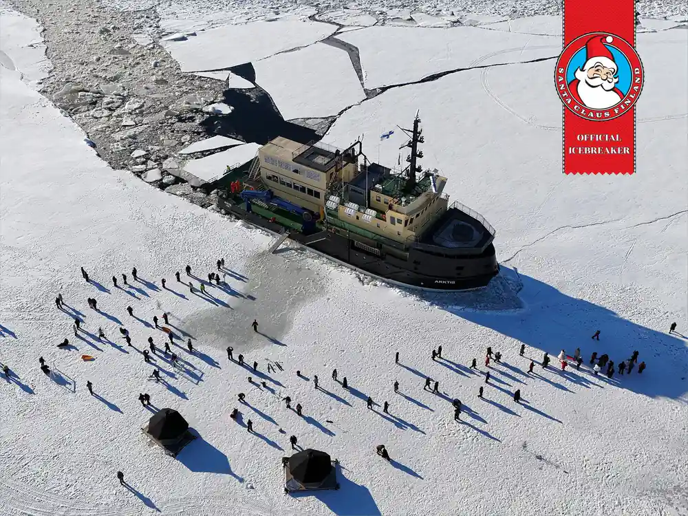 Aerial view of the ship with passengers spread out on the ice around it