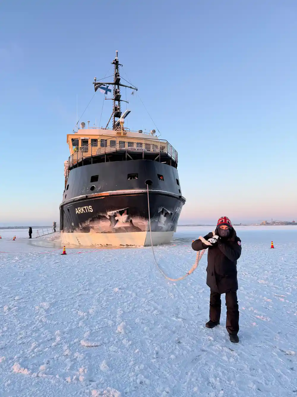 Arktis on the ice with a visitor in the foreground holding a rope