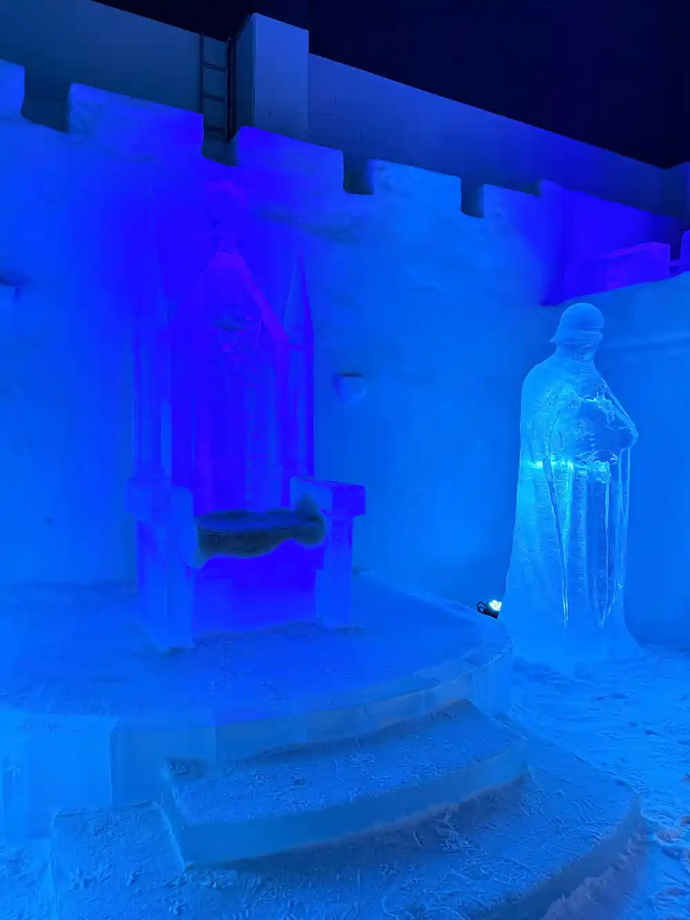 Blue-lit ice sculptures inside the snow castle