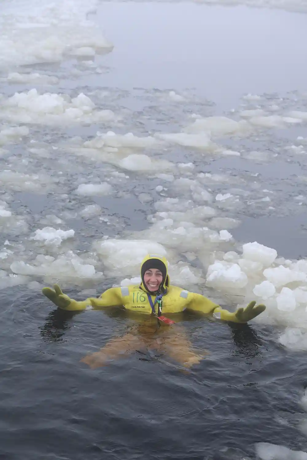 A floater in a yellow suit among pancake ice