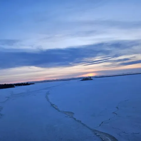 The frozen sea at dusk beside the icebreaker
