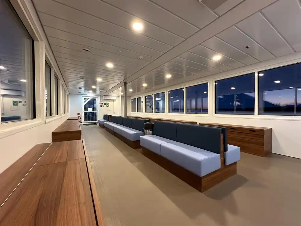 A long heated indoor deck with bench seating and windows
