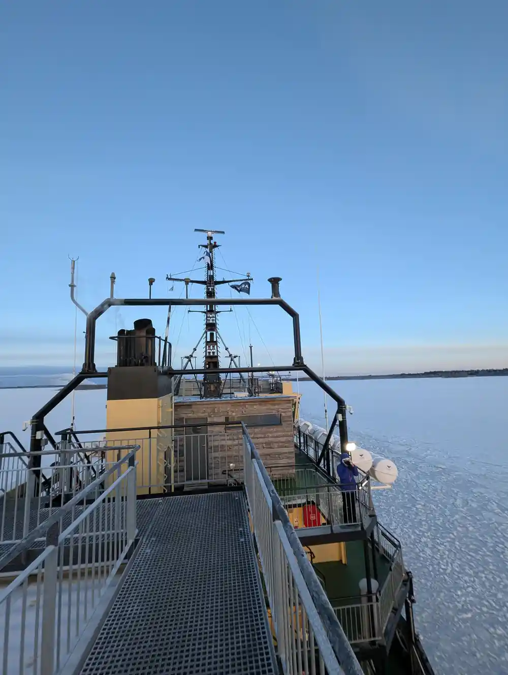 The ship funnel and upper deck under a pale winter sky